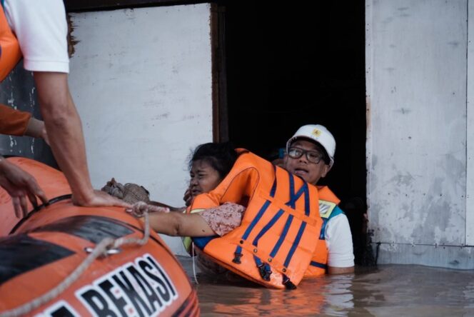 
					Direktur Utama PLN, Darmawan Prasodjo (kanan) ketika mengevakuasi seorang ibu bernama Murni (54) (kiri) dari banjir yang menggenangi rumahnya di Perumahan Nasional 1 Kayuringin Jaya, Bekasi, Jawa Barat pada Selasa (4/3).